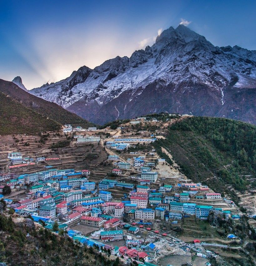 A panoramic view of Namche Bazaar with colorful buildings and Himalayan peaks