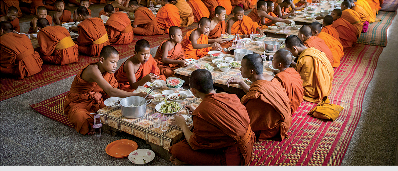 Monks and trekkers sharing Momos and tea at a mountain guesthouse