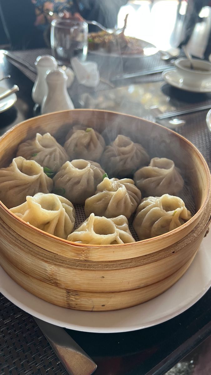 A steaming plate of local Nepalese momos (dumplings) and Thakali food in a tea house