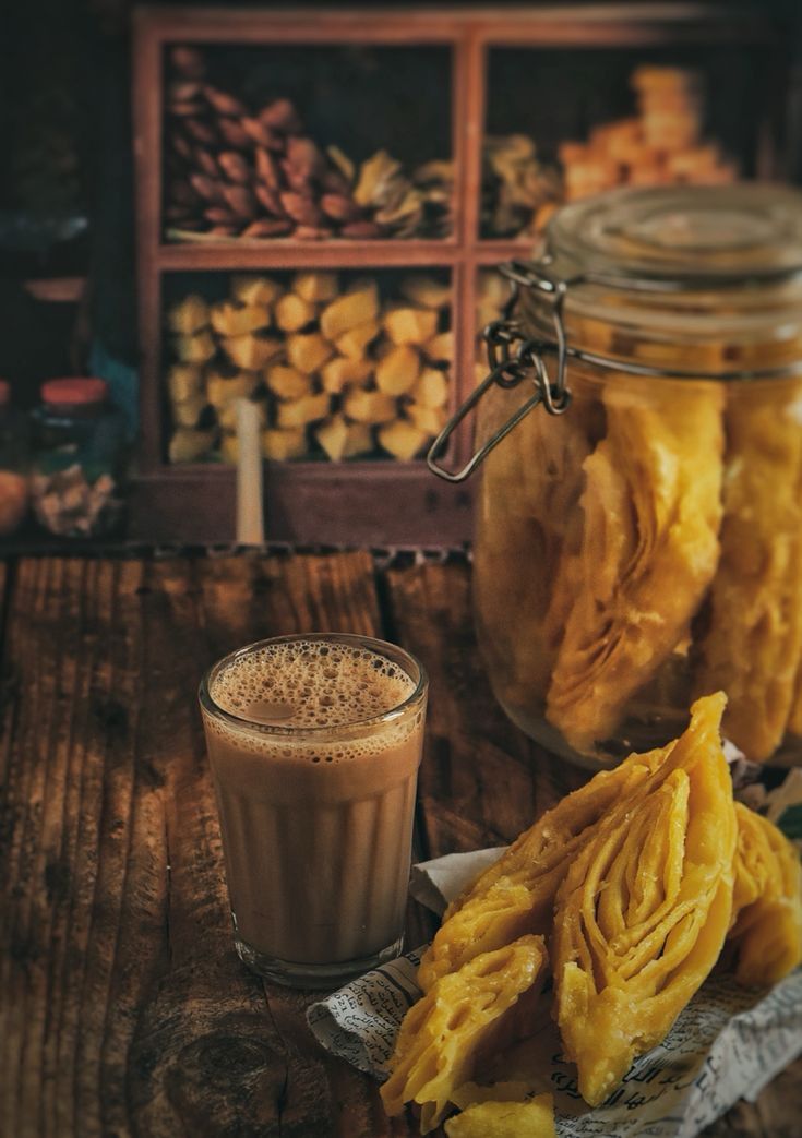 A cup of fresh Ilam tea served with traditional Nepali food (Sel Roti) against a blurred tea garden background