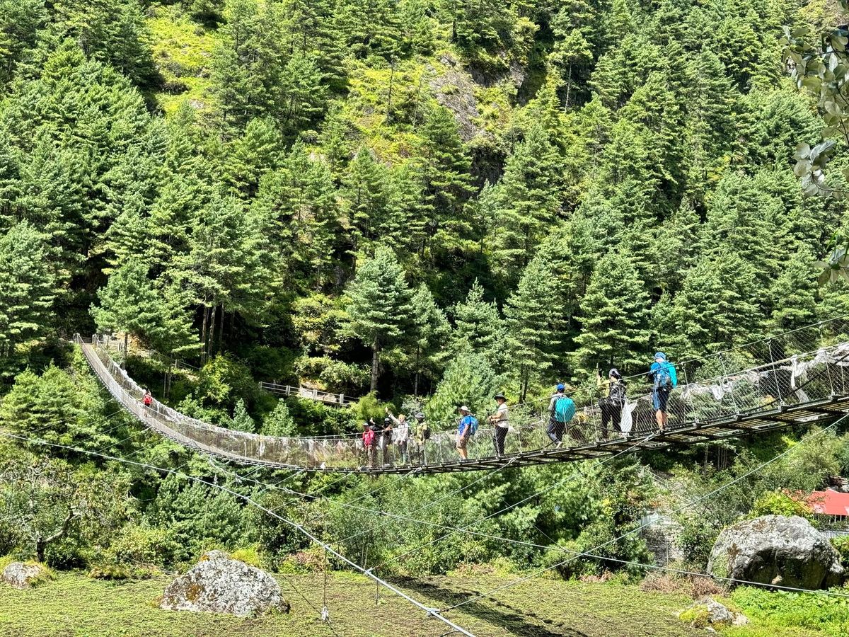 Trekkers crossing a suspension bridge on the Everest Base Camp trail