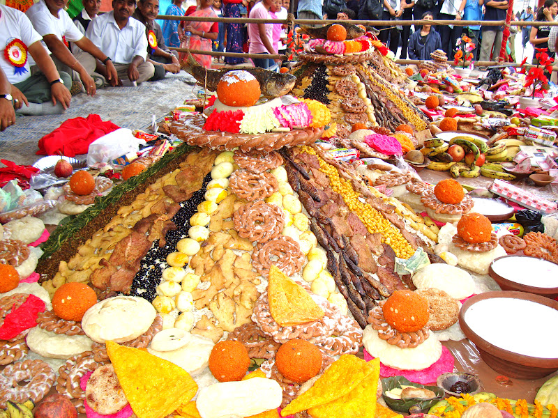 A Newari festival scene with family members sharing Samay Baji and pots of Juju Dhau.