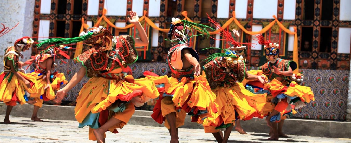 Sherpa performers in elaborate traditional attire during a cultural event.