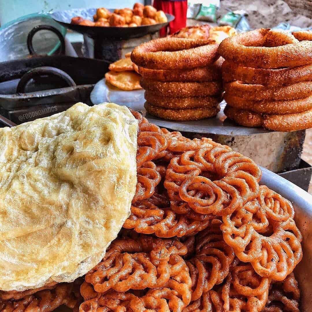 Ason market stall with piles of sel roti and sweet treats